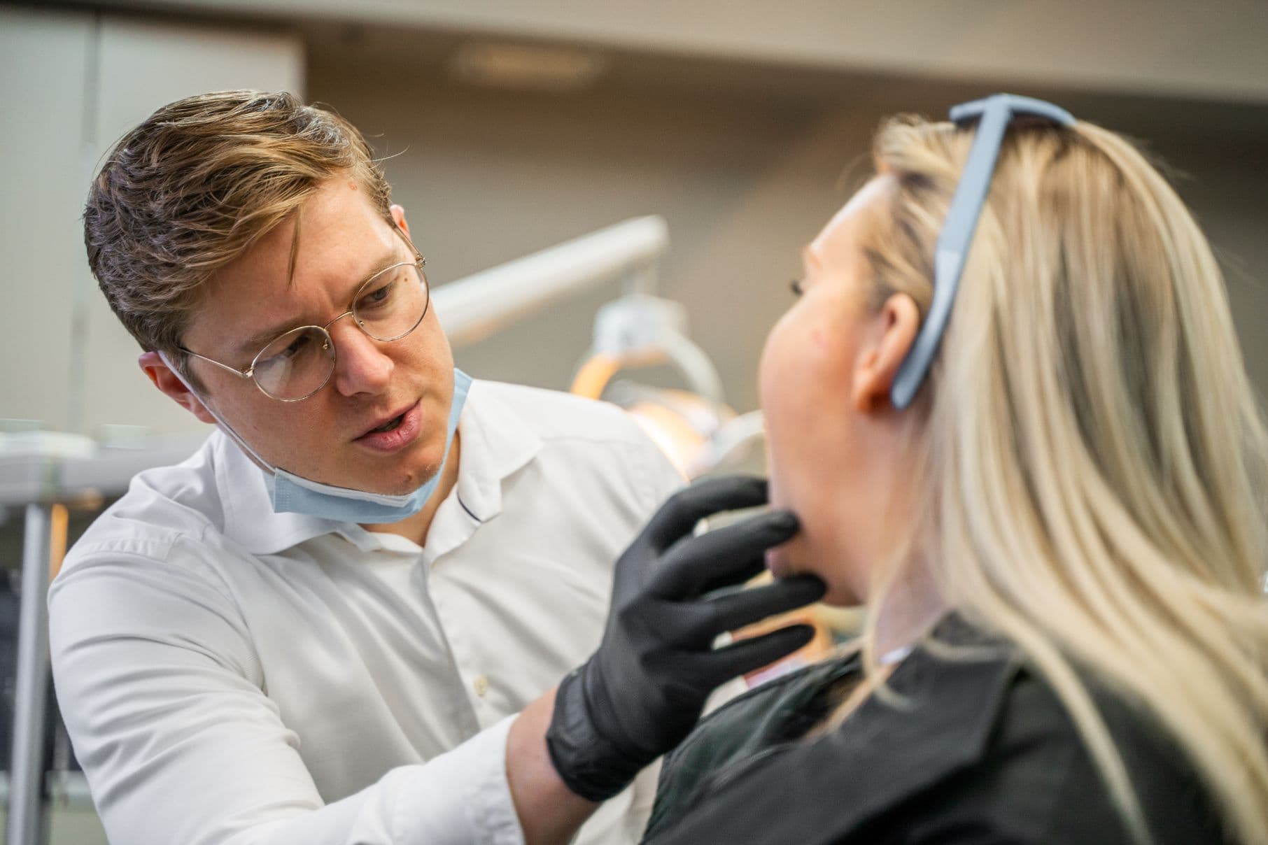 Dr. Adam is examining a patient's teeth.