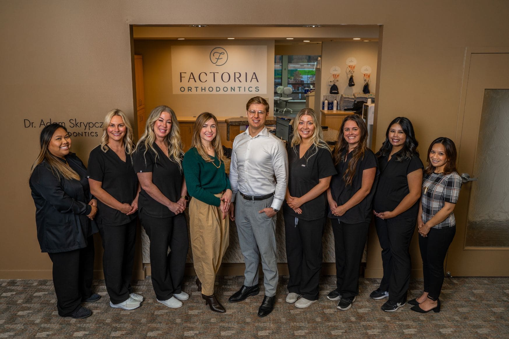 The team posing in front of the Factoria dental office.