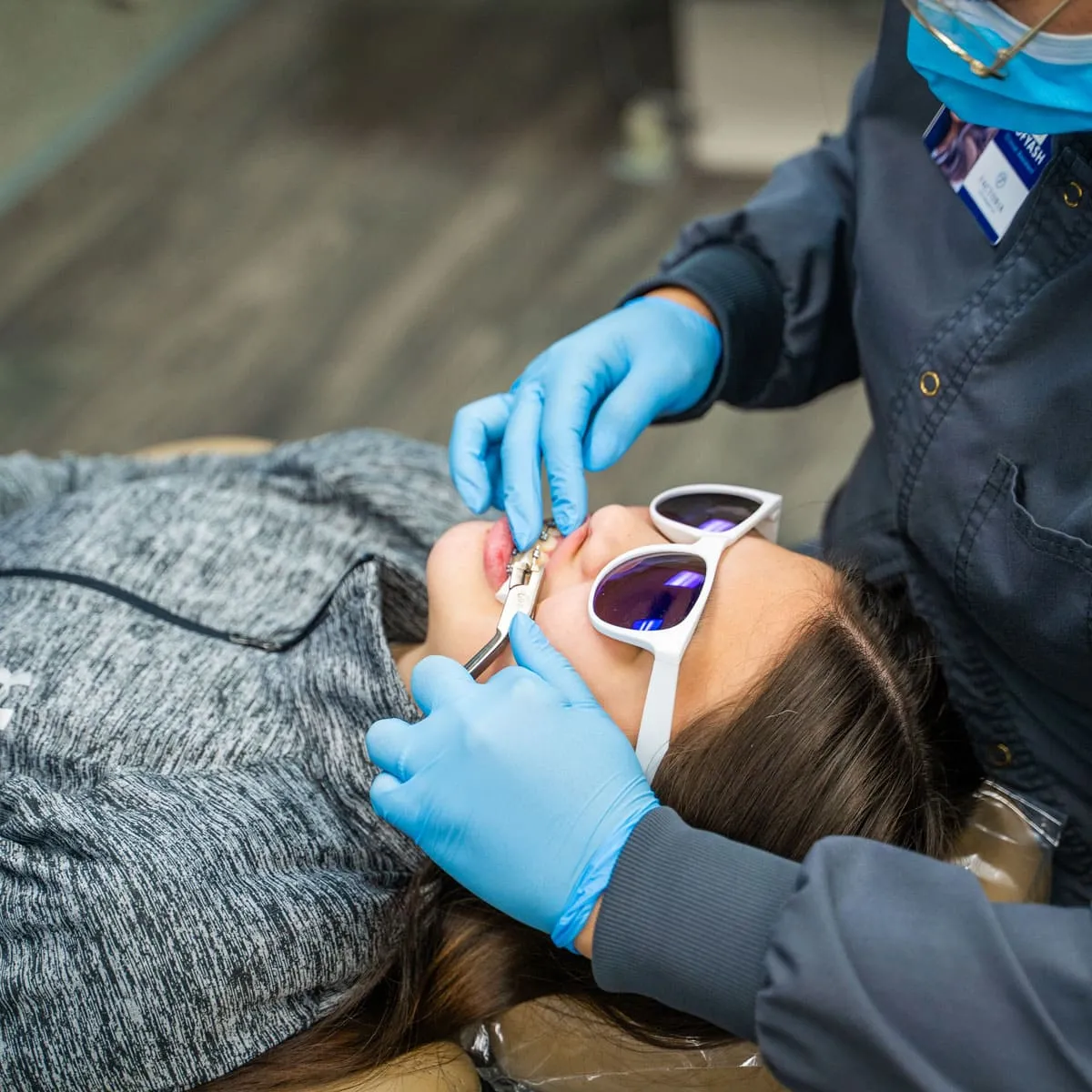 A woman is getting her teeth cleaned by a dentist.